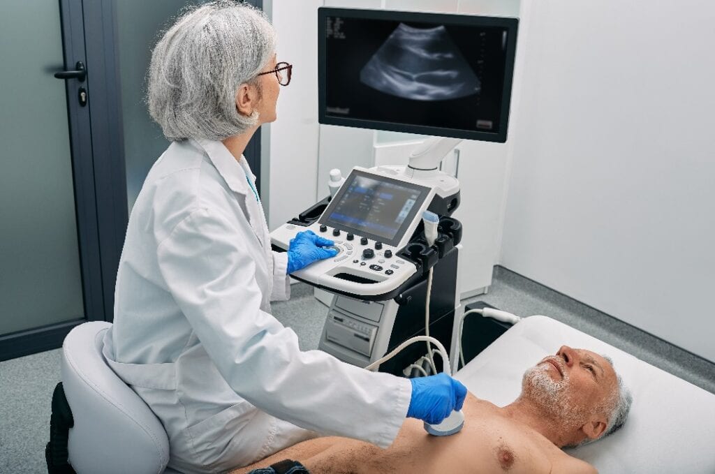 Heart ultrasound exam for senior man with ultrasound specialist while medical exam at hospital