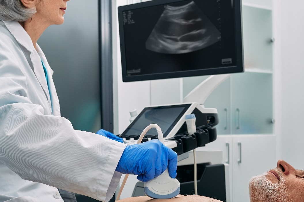 Herzultraschalluntersuchung bei einem älteren Herrn durch einen Ultraschallspezialisten im Rahmen einer medizinischen Untersuchung.